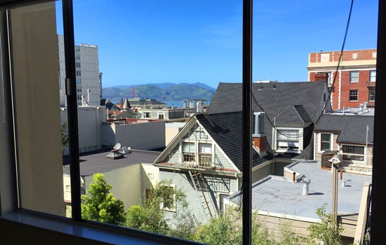 Living room view, rooftops, Golden Gate Bridge and Marin Headlands
